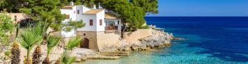 Cala Gat - Cala Ratjada Sonniger Strand der Cala Gat in Cala Ratjada auf Mallorca mit Wohnhaus im Hintergrund.