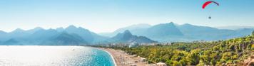 Antalya Panorama des Strandes von Paragliding in Antalya mit Bergen im Hintergrund.